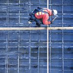 Caucasian worker nailing boards at construction site